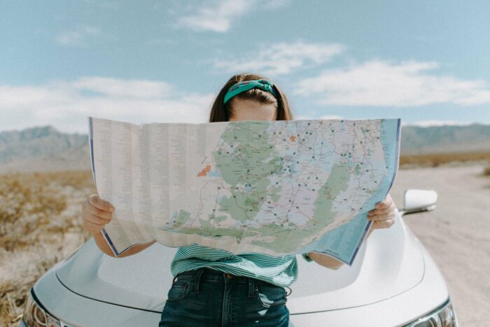 Picture of a woman holding a map to navigate the open road